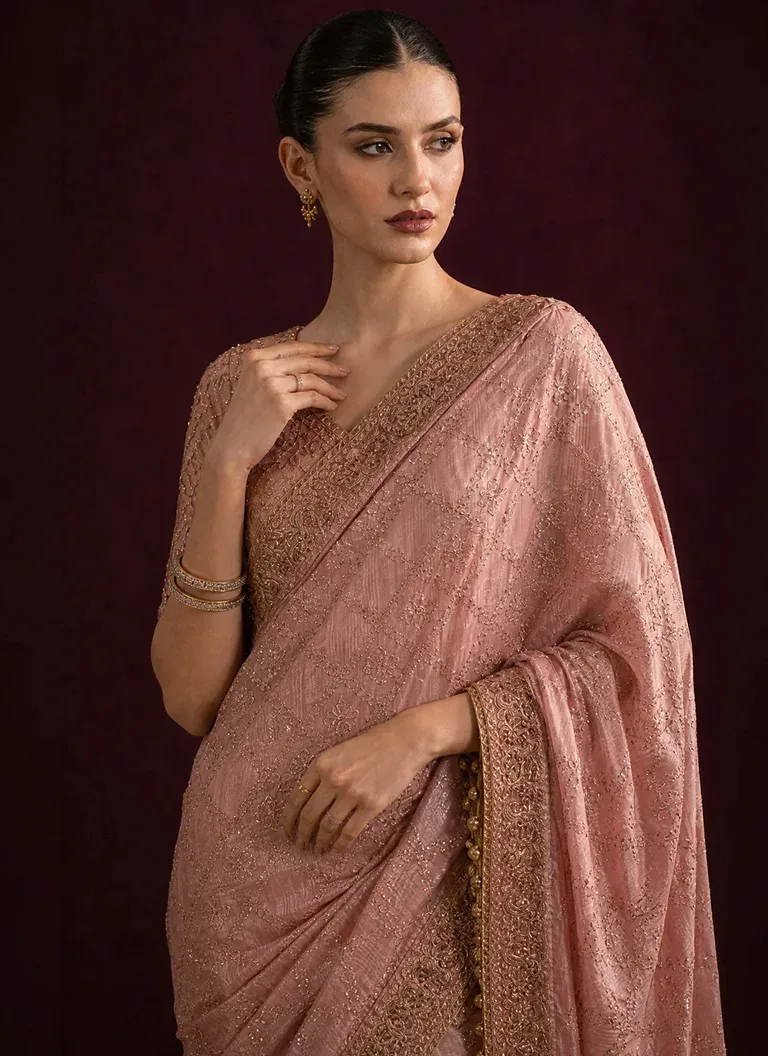 Pink net saree with matching embroidered blouse, sequin embellishments and elegant styling for weddings and formal occasions