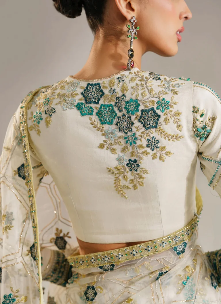 Pakistani white wedding guest saree with embroidered net fabric, decorative saree borders and elegant traditional detailing