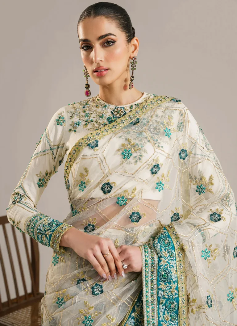 White net saree with hand embellished Korean raw silk blouse, embroidered sleeves and decorative Russian grip borders