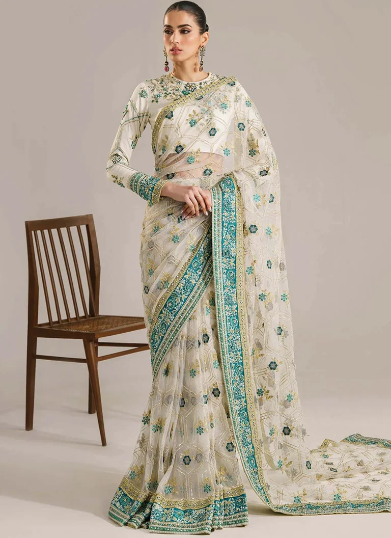 White Saree for Wedding Guests – Embroidered Net Saree White saree for wedding guests featuring embroidered net fabric and a hand embellished Korean raw silk blouse