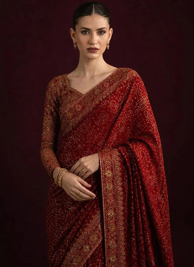 Maroon medium silk saree with embroidered blouse, organza sleeve borders and decorative saree pallu for wedding celebrations