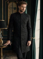 Full-length black sherwani for groom with black-on-black hand embroidery, sequins and band collar
