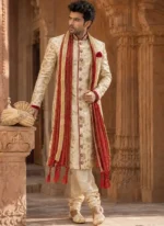 Ivory silk Jamawar groom sherwani with gold embroidery, red shawl and matching ivory khussa