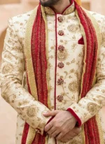Close-up of ivory groom sherwani with gold thread embroidery, zari collar and red shawl