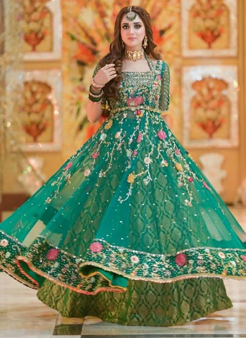 Emerald green Pishwas with a square neckline, twelve-kali flare and pink floral embroidery along the hem