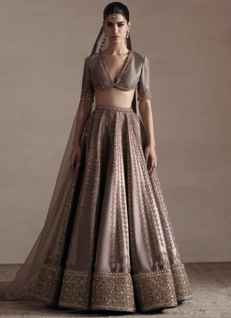 Gray Bridal Lehenga Choli with Criss-Cross Keyhole Back – Gold Embroidery Back view of gray baraat bridal lehenga choli featuring a criss-cross keyhole blouse design, gold embellished straps, silk fabric and flowing embroidered lehenga.