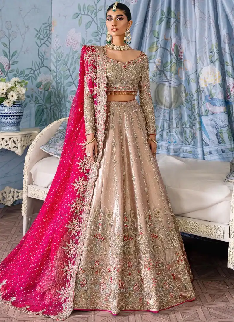 Beige Baraat Lehenga Choli with Scalloped Fuchsia Dupatta Beige baraat lehenga choli front close-up with gold embroidered sweetheart neckline and fuchsia floral dupatta