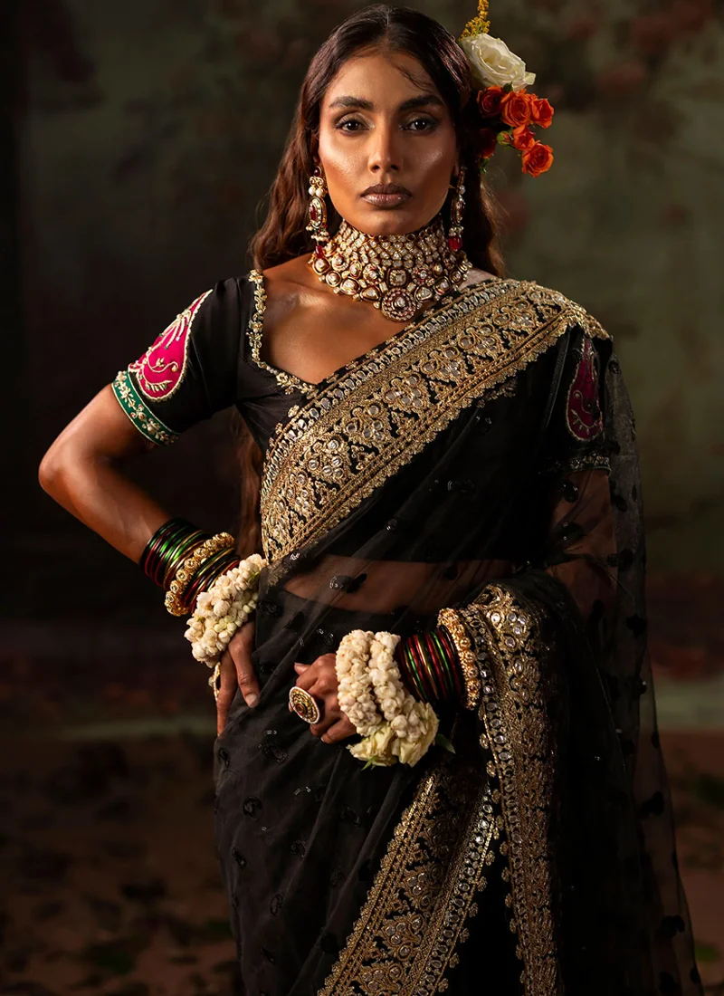 Black bridal saree, full-length front view, with sheer pallu over the head and gold edging.