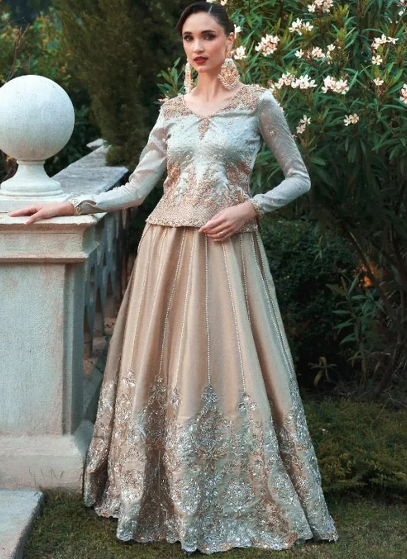 Champagne Baraat Lehenga Kurti with Vertical Pearl Strands Champagne lehenga with pale aqua blue top, seated front view showing a scalloped floral hem