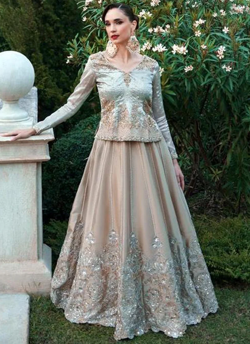Champagne bridal lehenga and aqua blue kurti, standing front view with ornate silver and gold hem motifs