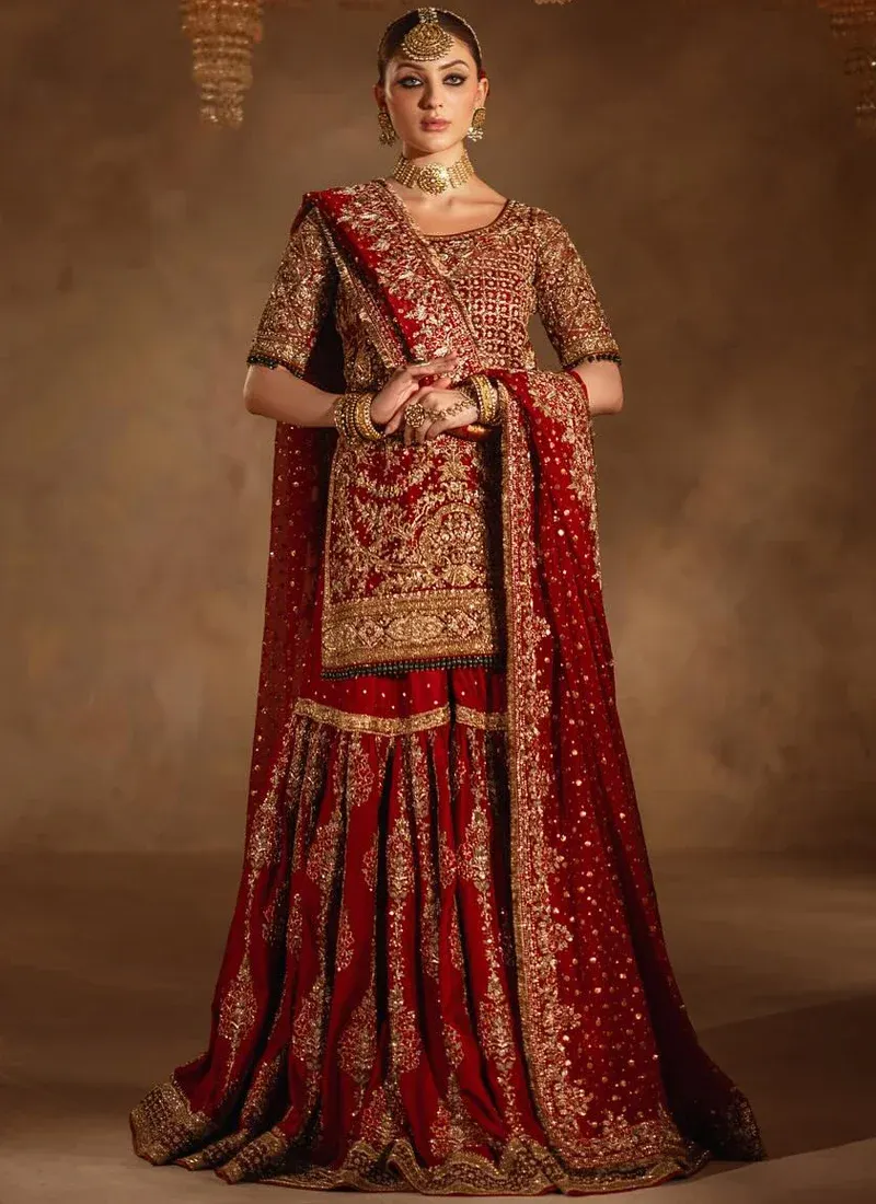 Deep Red Baraat Farshi Gharara with Green Bead Fringe Deep red bridal gharara upper-front view showing gold lattice embroidery and green bead sleeve trim.