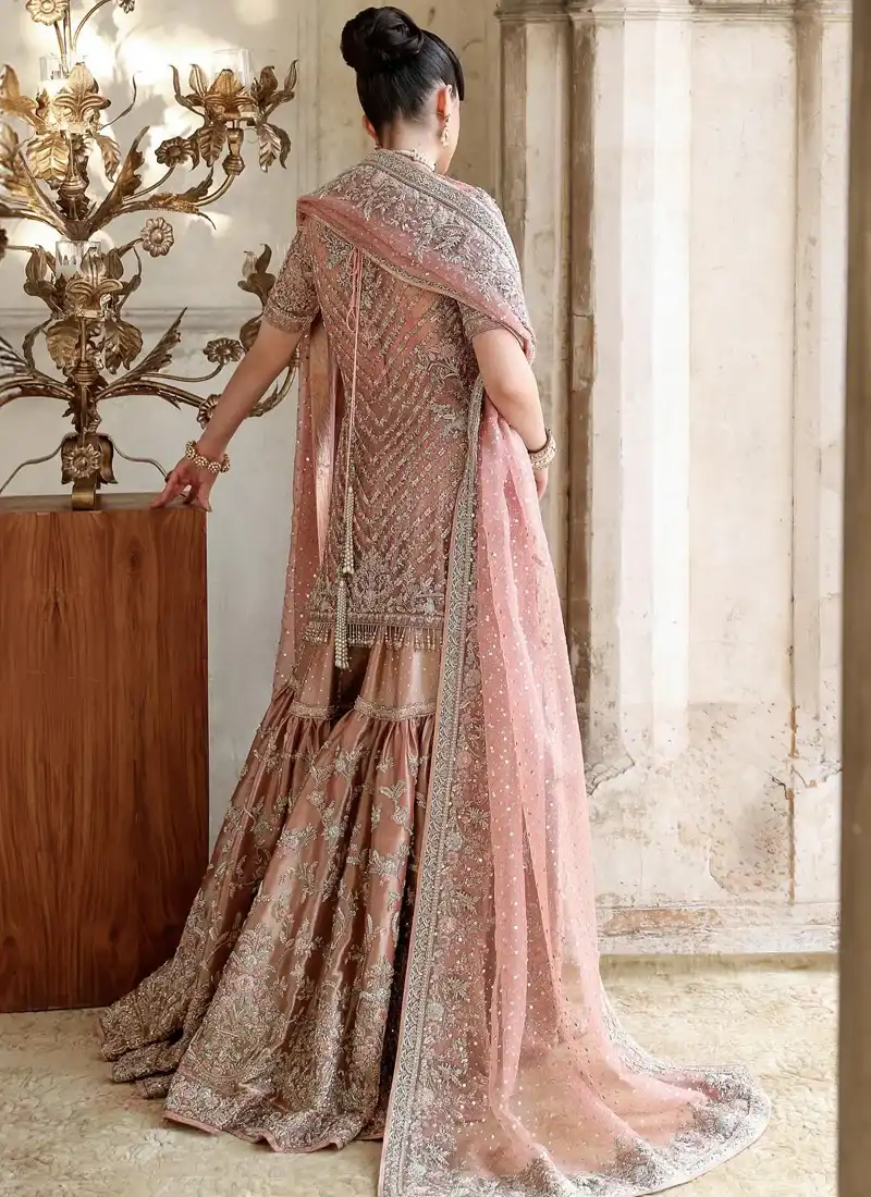 Dusty pink bridal gharara full back view with tiered flares and a sheer floral-bordered dupatta.