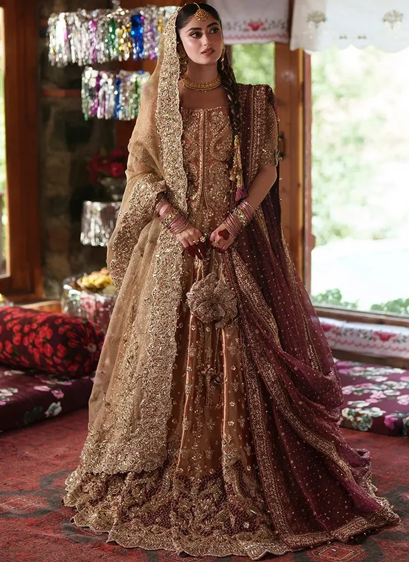 gold-baraat-lehenga-choli-with-scalloped-floral-hem-01 Front view of the gold lehenga choli with a rust-gold blouse, champagne veil on one side, wine dupatta on the other and a scalloped floral hem