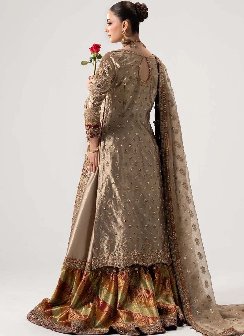 Antique gold gharara suit front view with ornate floral hem embroidery and rust-sage patchwork flare