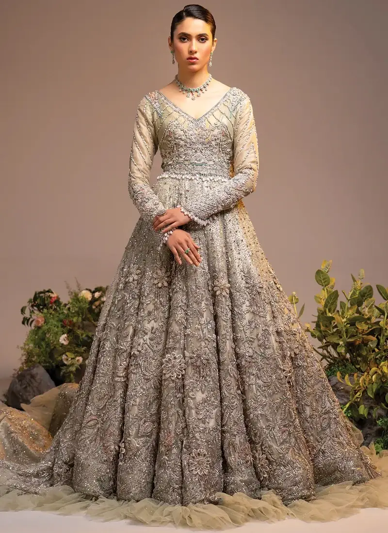 Ivory Walima Gown with Scalloped Cutwork Dupatta Ivory bridal gown back view showing a V-shaped back, silver floral embroidery and layered tulle hem frills.