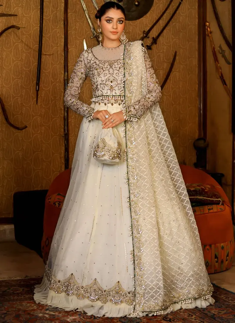 Ivory Walima Lehenga Choli with Pearl-Tasselled Jaal Dupatta Ivory bridal choli sleeve close-up with metallic floral scrollwork beside sheer quatrefoil jaal dupatta