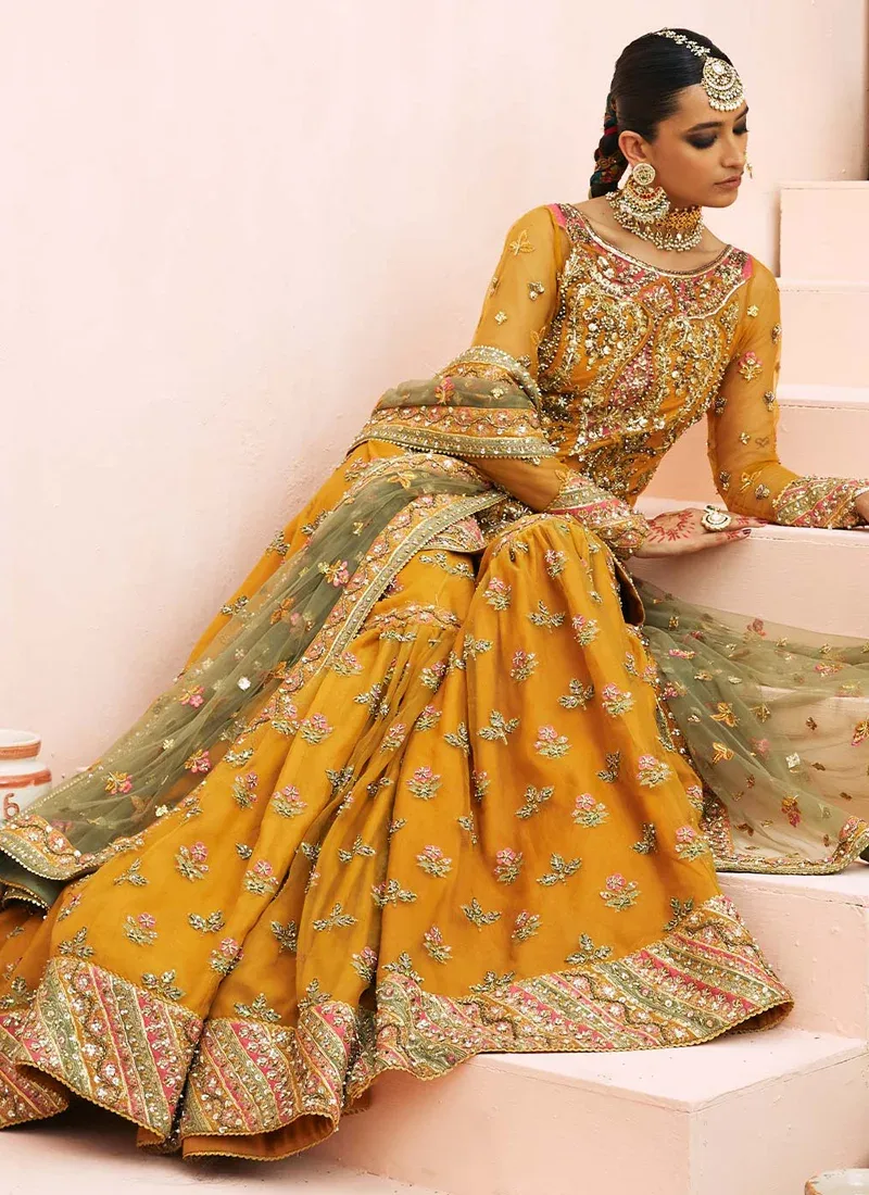 Mustard gharara suit full-length front view with flared trousers, pink chevron borders and olive net dupatta