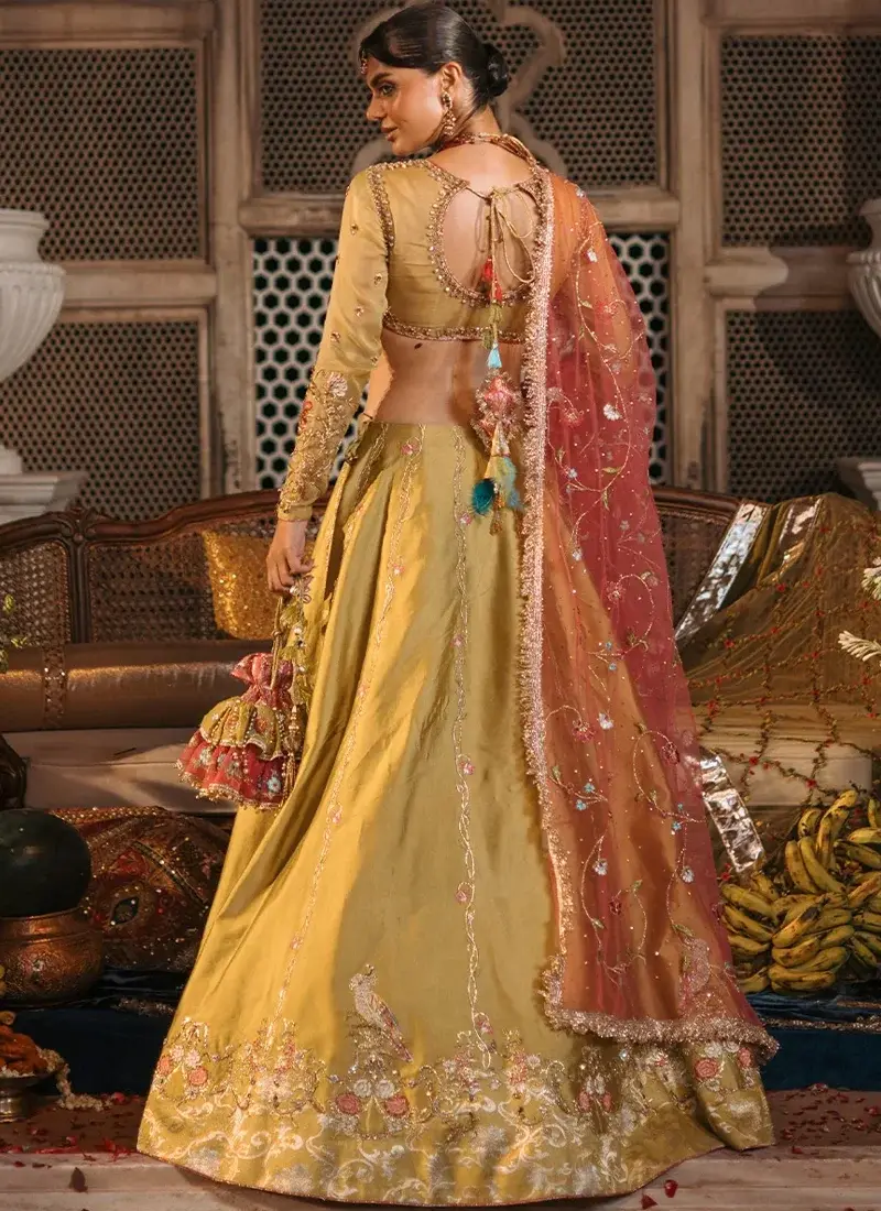 Mustard mehndi lehenga choli side view with gold vine embroidery and coral dupatta