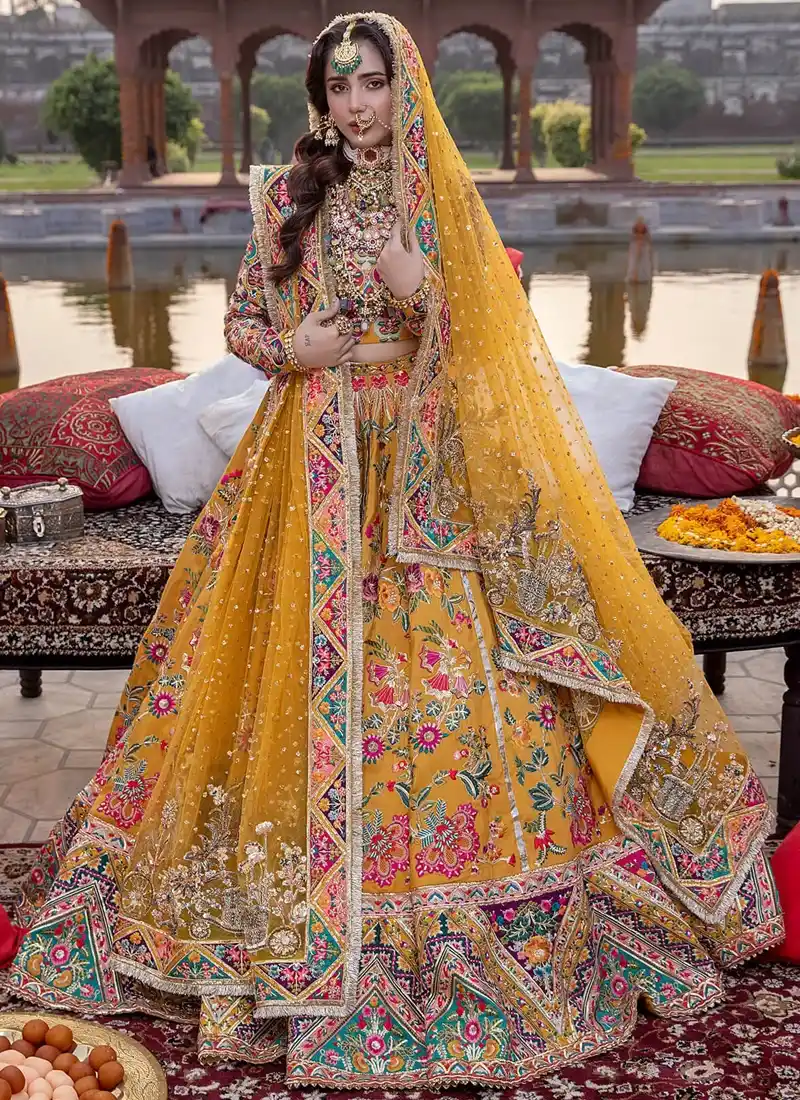 Mustard Mehndi Lehenga Choli with Multicolour Chevron Borders Mustard bridal lehenga choli full front view with sheer embellished dupatta and multicolour floral ghera