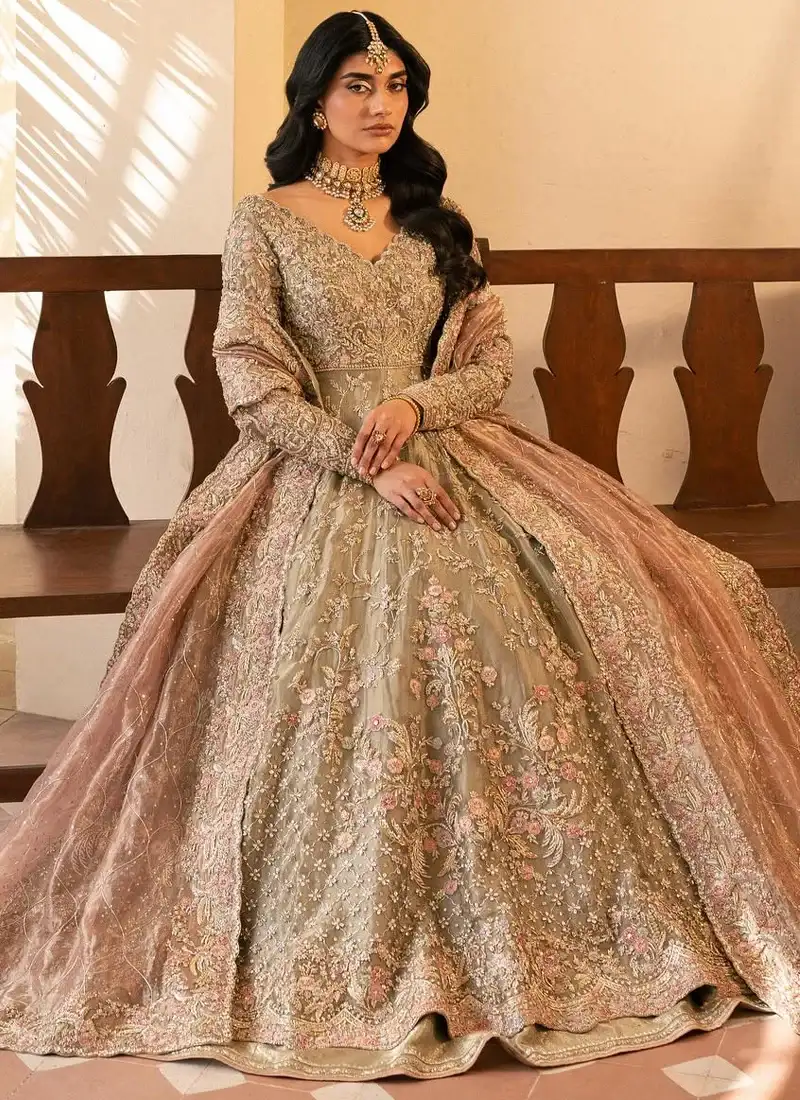 Olive walima pishwas seated front view showing gold floral embroidery and a tea-pink bordered dupatta