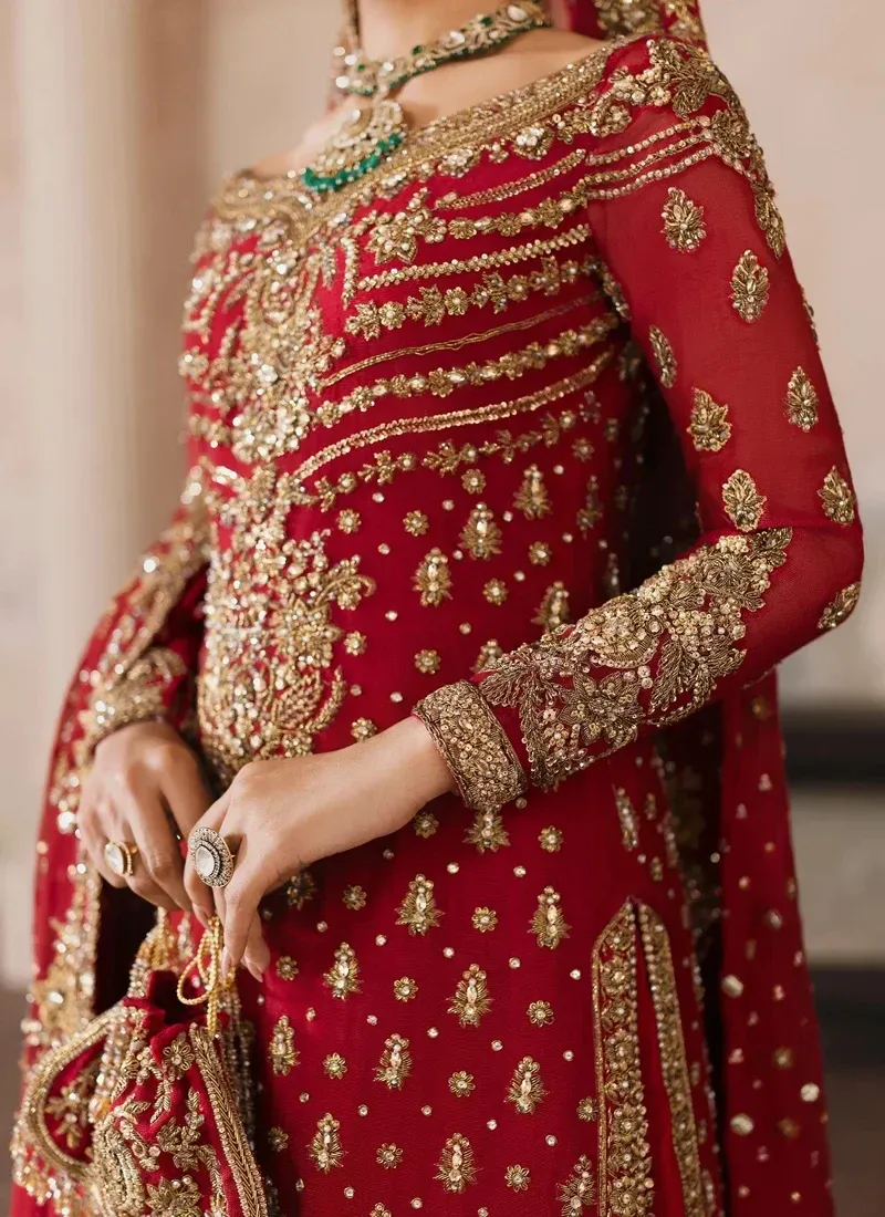 Red bridal long shirt and lehenga side view with ornate cuffs and floor-sweeping gold-edged dupatta