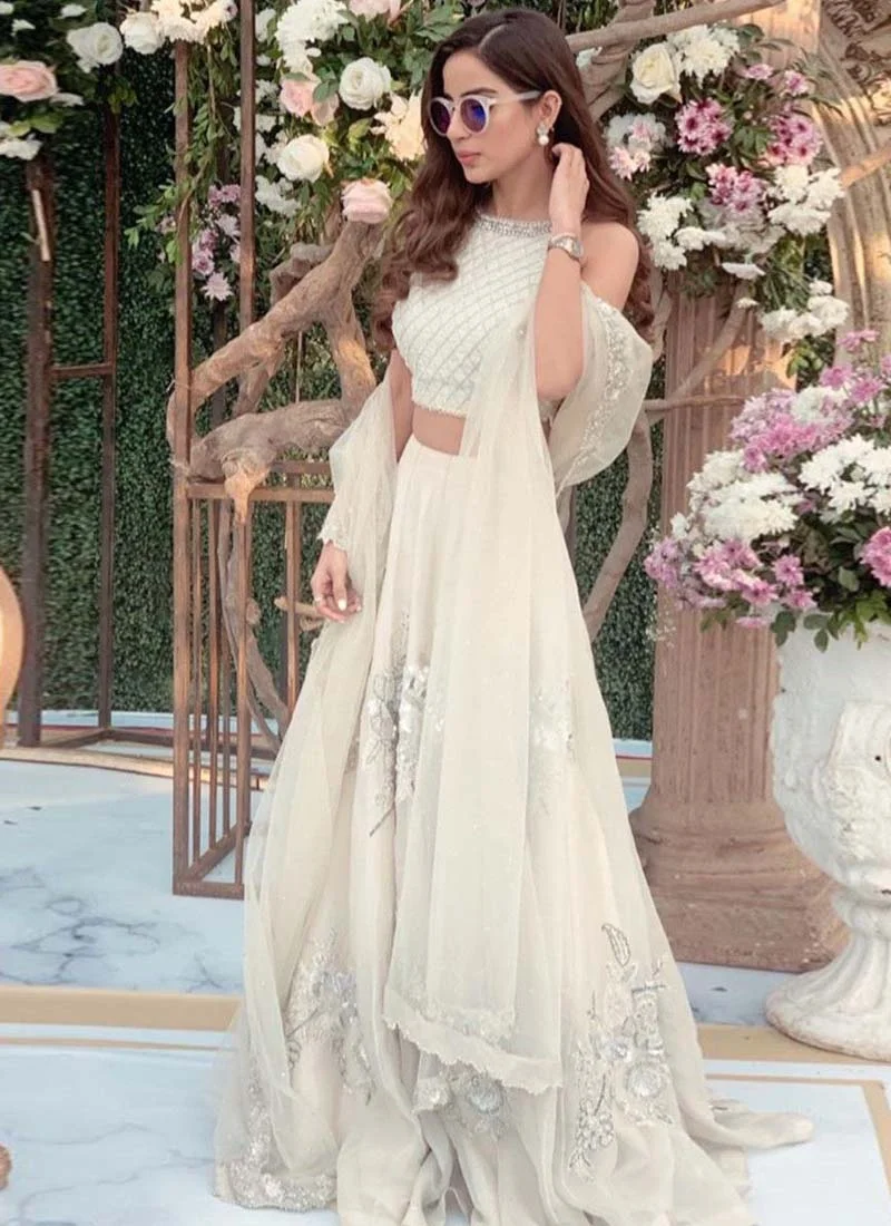 White lehenga choli, front bodice close-up showing silver diamond lattice embroidery and a round neckline.